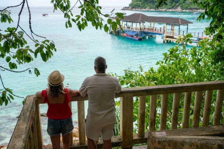 Tourists admiring tropical island seascape from scenic overlook