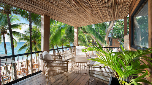 Beachfront hotel balcony with ocean view and palm trees